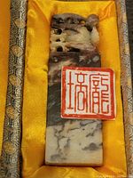 Full view of the stone ink blotter resting in original box lined with yellow fabric