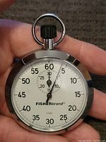 Front view of the vintage Fisher brand stopwatch showing the dial and button.
