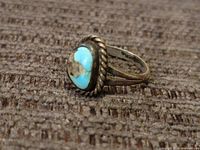 Side angle showing turquoise stone and twisted rope bezel on sterling silver ring.