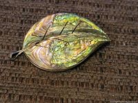 Front view of the leaf brooch showing abalone shell inlay and silver leaf veins detail.