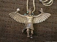 Full view of the silver-tone Kachina figure pendant with outstretched wings on box chain.