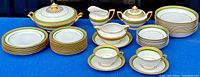 Overview of entire dinnerware set showing tureen, plates, cups, saucers, gravy boat, creamer, and sugar bowl.