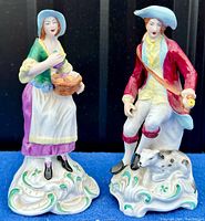 Front view of both porcelain figurines on blue cloth background