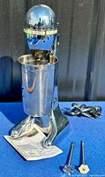 Full view of Hamilton Beach Classic Drinkmaster milkshake mixer with attached stainless steel mixing cup, showing polished chrome finish and power cord.