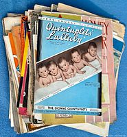 Pile of assorted antique piano sheet music, notable cover showing 'Quintuplets Lullaby' with illustration of five babies.