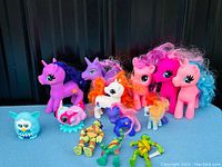 Full lot of toys including My Little Pony figures, TMNT figures, and two Furby-style toys shown together