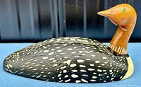 Side view showing detailed spotted black and white body and brown neck of the carved loon decoy