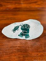 Front view showing frosted glass with dark etched Inuit figure holding a fish