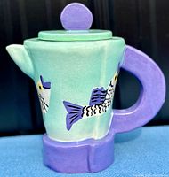 Front angle view showing fish design, colors, and shape of coffee pot