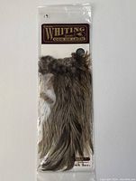 Front view of Whiting Farms fly tying saddle hackle packaging with visible feathers inside the resealable bag.