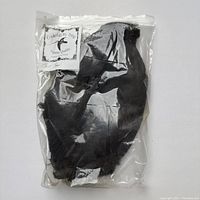 Full view of the sealed plastic bag containing black coot skin material for fly tying, with visible label.