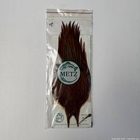 Front view of brown hackle feathers in original plastic bag with Metz logo and label.