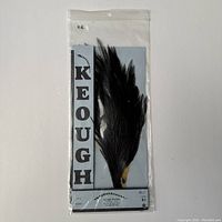 Packaged black hackle feathers on blue backing card with visible Keough branding and product details.