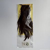 Front view of the pack of dyed fiery brown saddle hackle feathers in sealed clear plastic bag.