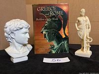 Photo showing the National Geographic Greece and Rome book with a bust and another figurine on either side of the book.