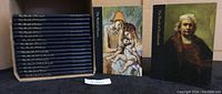 Set of 18 blue hardcover books in slipcase with two volumes displayed in front showing Rembrandt and Frans Hals covers.