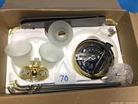 Box containing ceiling fan components: four blades, motor housing, three glass light globes, mounting rods, and chain pull switch.