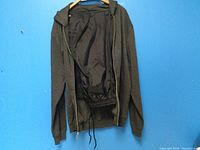 Men's dark gray zip-up hoodie interior showing smooth lining and drawstring bottom hem