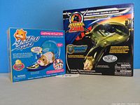 Front view of the Zhu Zhu Surfboard and Zhu Zhu Mission Control boxed toys, showing packaging and branding.