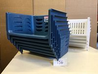 Stack of six blue Sterilite stacking bins with four white stacking bins behind, showing the size and count of bins.