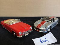 Front view of the red Mercedes 190SL and silver Shelby Series convertible models showing detailed exterior and interior features.