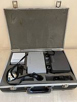 Open vinyl carrying case containing two Polaroid 103 cameras with accessories and manuals secured in foam cutouts