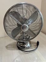 Full front view of vintage metal Hunter oscillating table fan showing metal blades and cage with logo center.