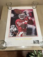 Full view of the poster 'The Record Breaker' showing a football player catching a ball with water staining and wrinkling visible on edges.