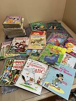Photo of a mixed stack of vintage Little Golden Books showing front covers such as Chipmunks ABC, Duck and His Friends, and Mickey Detective Mickey.
