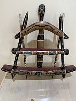 Front full view of the hand-painted wooden wall hanging with multiple carved and painted elements displaying stylized animals and patterns.