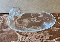 Clear Steuben crystal scoop bowl with snail-shaped handle, showing overall shape and design