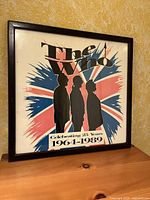 Framed The Who concert poster leaning against wall showing full design with silhouettes and Union Jack background.
