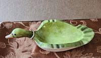 Top angled view of vintage mallard-shaped ceramic ashtray showing detailed green head and body with basin area inside.