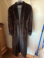 Front view of full-length mink coat hanging on hanger
