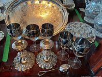 Image showing two silverplate candlesticks, five silvered goblet-style glasses, silver tea diffuser, and part of silverplate tray in background