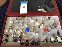 Tray showing all jewelry pieces and two 14K rings on paper labeled “14K”