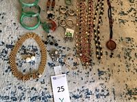 Overview of all jade bangles, carved jade rings, necklaces, bracelets, earrings and brooch laid out on rug