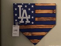Wooden wall plaque shaped like a baseball home plate with the LA Dodgers logo and American flag design in blue and wood tones.