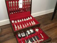 Presentation chest open showing upper and lower trays filled with flatware
