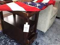 Side and front views of the dark wooden end table showing drawer, shelf, and surface.