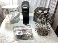 All items together on white tablecloth: Keurig espresso machine, thermal carafe box, stainless steel pod holder, Seychelle water filter pitcher with instructions in bag.