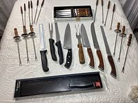 Full set of knives and forks including fondue forks and cutting knives.