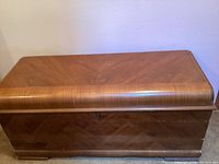 Front side view of Lane cedar trunk showing waterfall lid and patterned wood exterior.