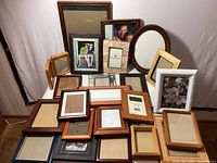 Full collection of assorted frames stacked and arranged together against a wall.