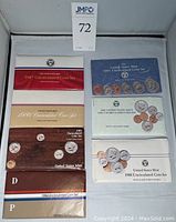 Overall view of 1984-1989 and 1991 United States Mint uncirculated coin sets with varied packaging and design showing both Denver and Philadelphia mint marks.