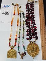 Overview of three necklaces side by side with ruler