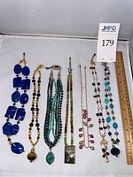 Overview of seven necklaces laid out with ruler