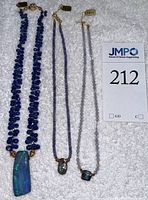 Three necklaces laid flat with lot card