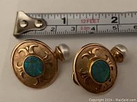 Front view of both earrings with measuring tape overhead showing approximately 1⅛ inch diameter discs.