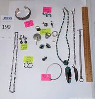 Overhead view showing all necklaces, bracelets, earrings and ring arranged with ruler